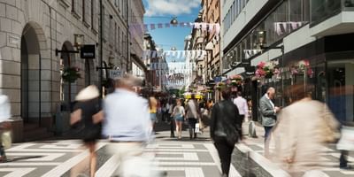 People bustling around Biblioteksgatan street near The Sparrow Hotel