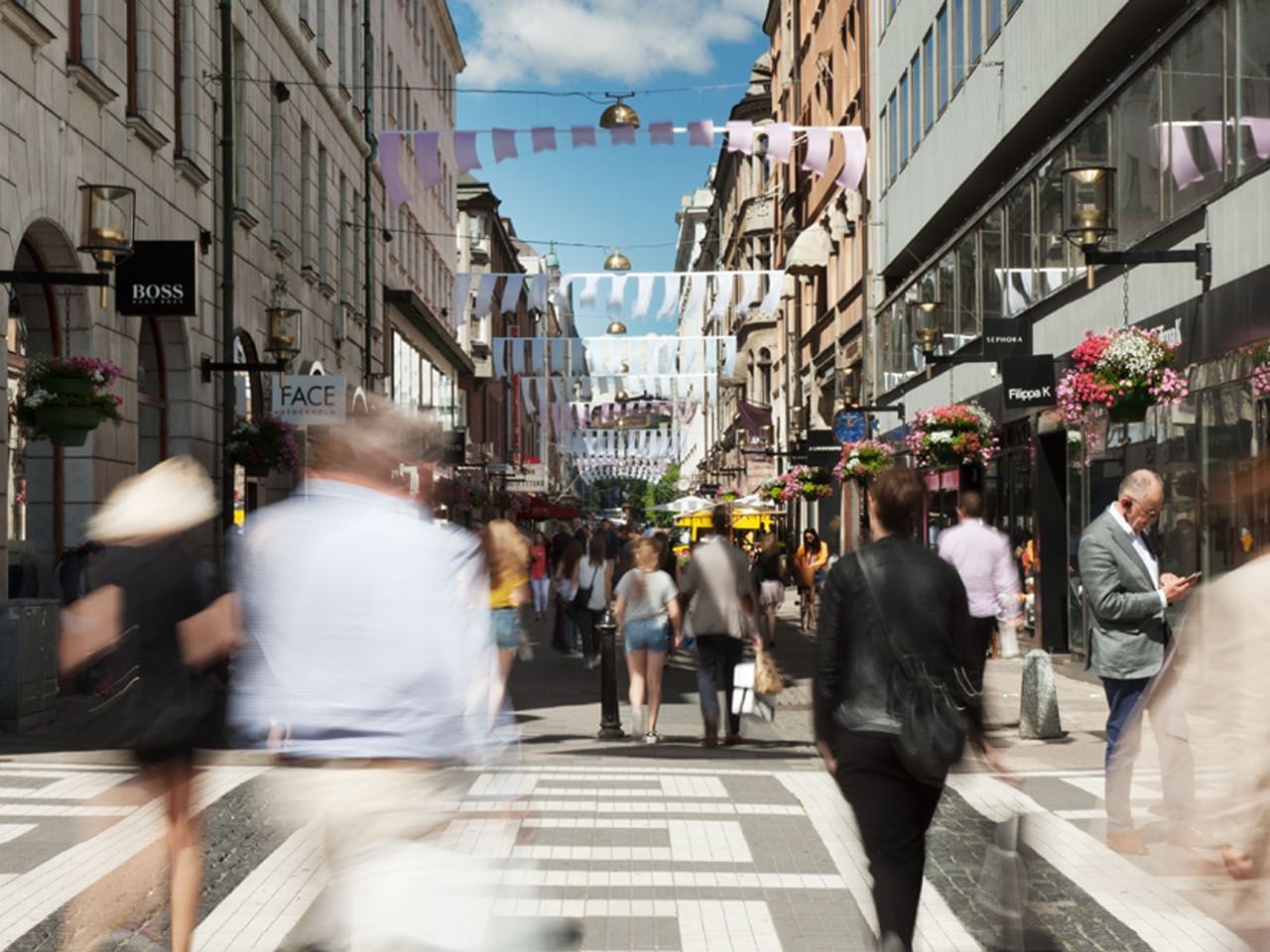 People bustling around Biblioteksgatan Street near The Sparrow Hotel