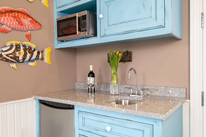 Kitchenette with appliances, fresh flowers & a bottle of wine in Superior Loft Cottage at Retro Suites Hotel