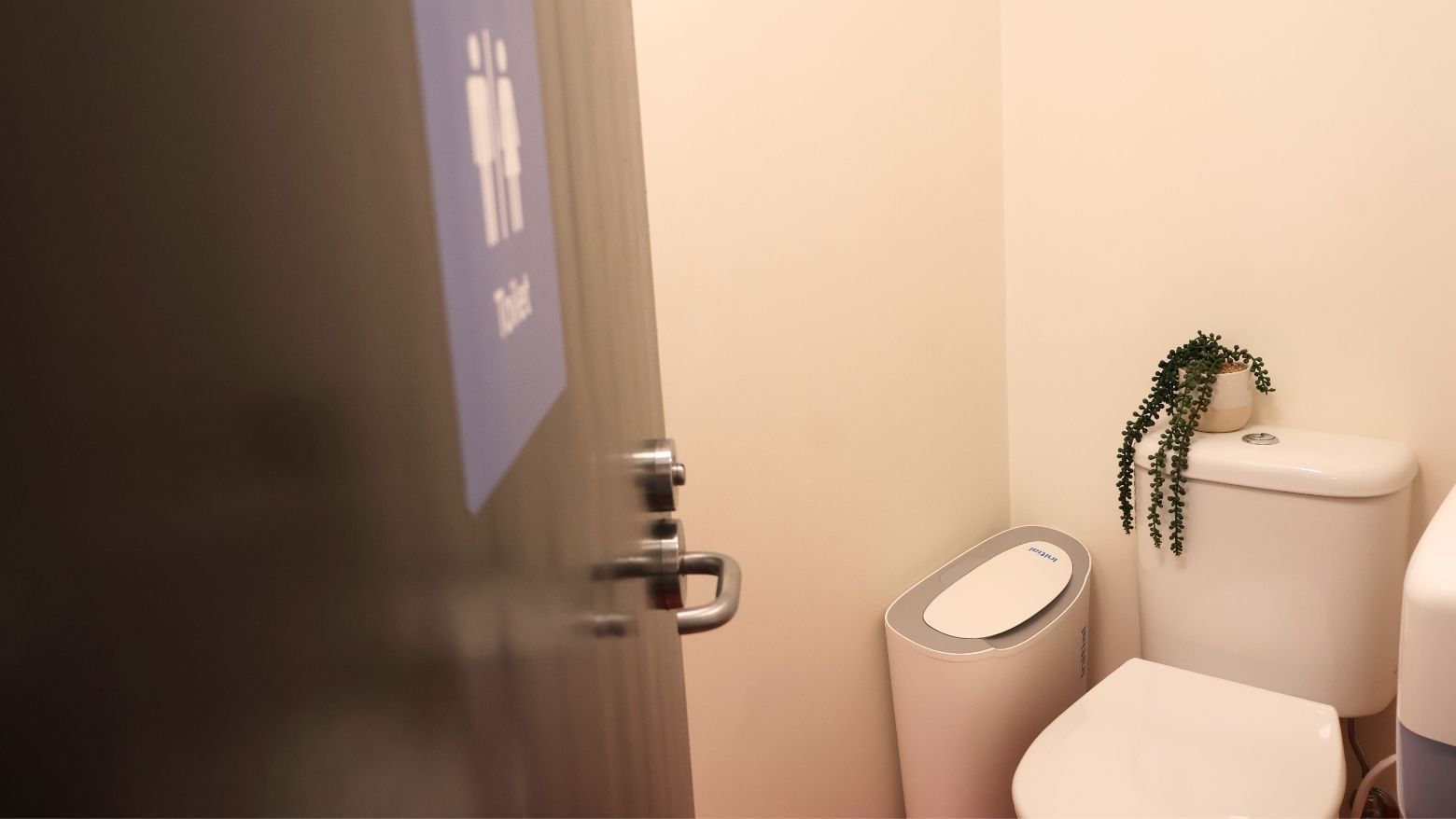 Clean bathroom with toilet, plant, and trash bin at La Trobe University Hillside Apartments.