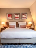 Bed with side tables near bathroom door in Junior Suite at Warwick Grand Place Brussels