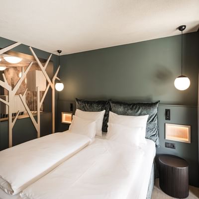 Modern bedroom with green wall, twin beds, wooden floor, and a unique wooden structure with lights.