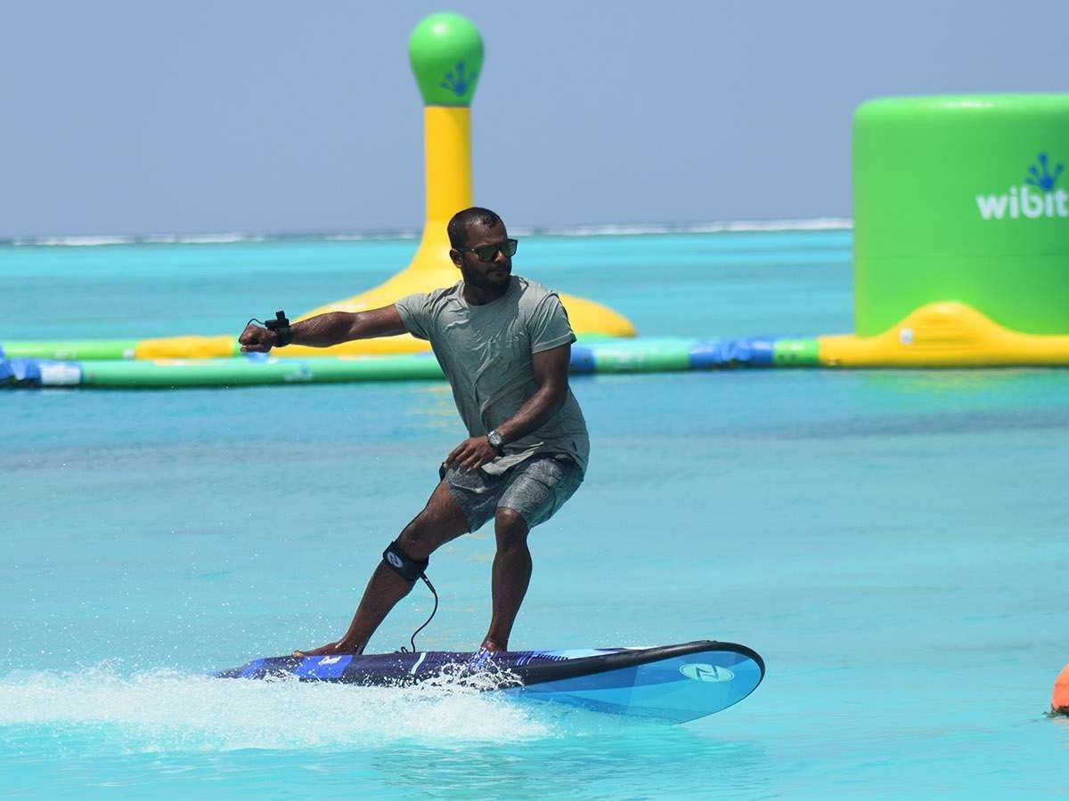 A surfer on E-surfing in the sea near The Signature Collection