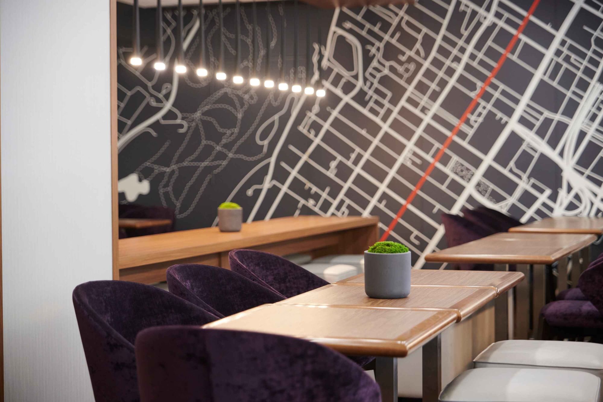 Espace Ste. Catherine at Warwick Le Crystal – Montreal with plush purple chairs and a city map wall graphic