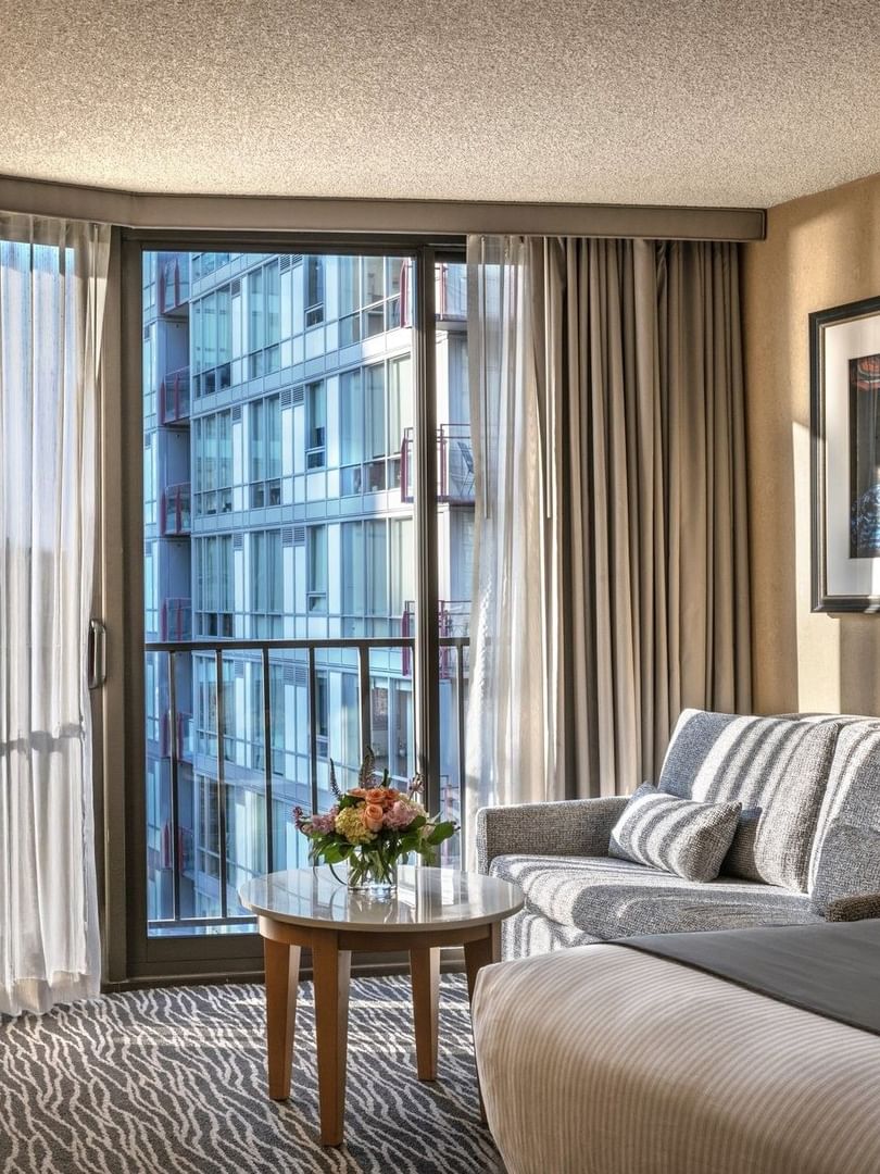 Grey sofa by a marble table and desk chair under a framed photo in Premier Room at Warwick Seattle