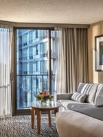 Grey sofa by a marble table and desk chair under a framed photo in Premier Room at Warwick Seattle