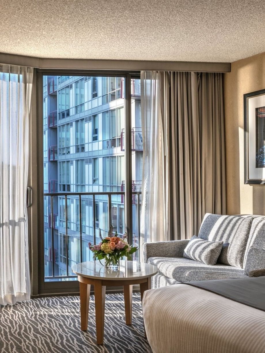 Grey sofa by a marble table and desk chair under a framed photo in Premier Room at Warwick Seattle