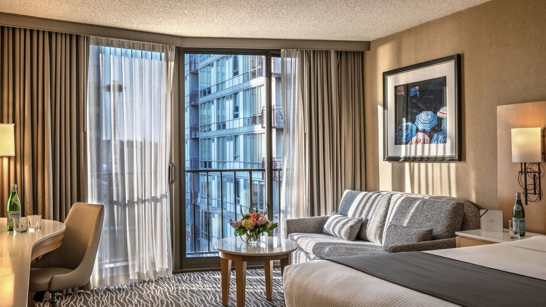 Premier Room features Grey sofa by a marble coffee table under a city view window at Warwick Seattle