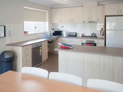 Modern kitchen with dining area and appliances at La Trobe University Regional Housing – Shepparton.