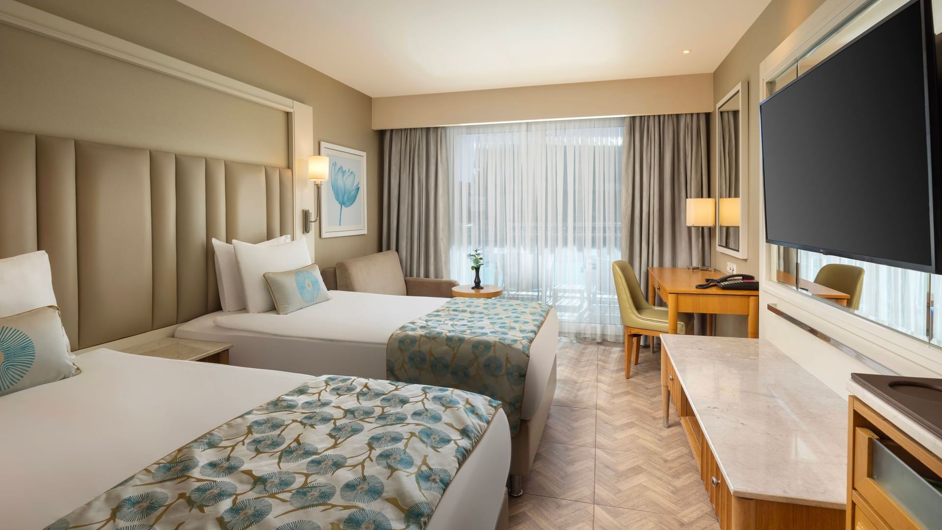 A stylish hotel room design with two beds, a wardrobe, and a television at Titanic Deluxe Lara.