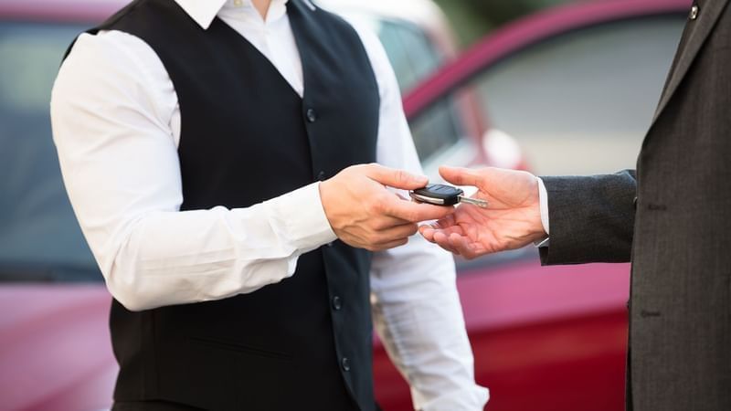 Close-up of a valet handing over a key at Warwick Le Crystal