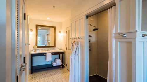 Bathroom area with hanging bathrobes in Resort suite at Watersound Inn