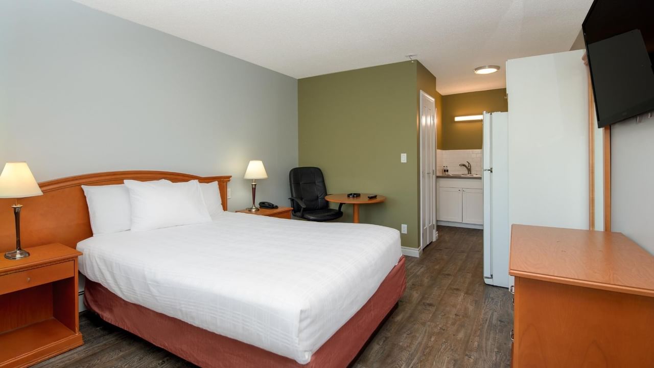 Guest room at Coast Red Deer Hotel with queen bed, desk and TV