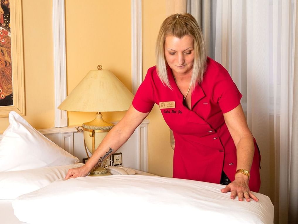 Housekeeper setting up a bed at Liebes Rot Flueh