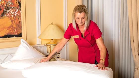 A housekeeper making a bed in a room at Liebes Rot Flueh