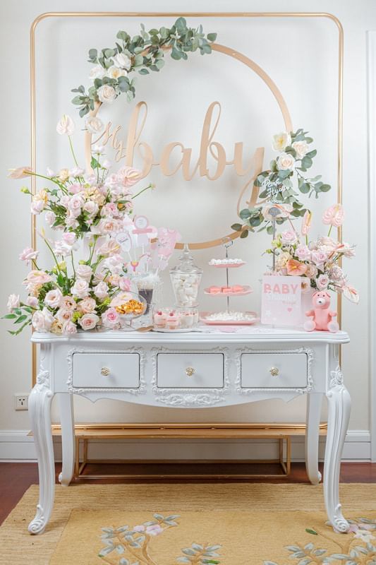 Beautifully decorated baby shower table with pink floral arrangements, desserts, and a My Baby sign at Park Hyatt Saigon