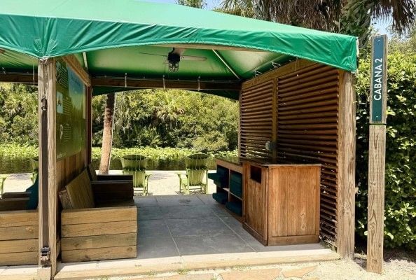 A wooden cabana with a storage, a couch, and a private sandy island overlooking the Wekiva River at Wekiva Island.