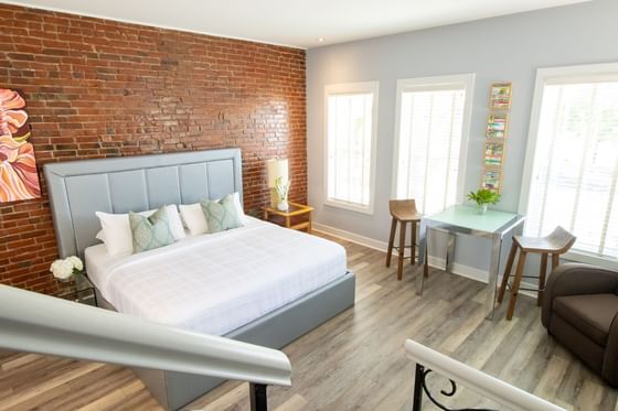 Elevated view of the bedroom with brick wall, dining table & sofa in Premiere Loft Town & Country at Retro Suites Hotel