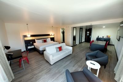 Angle view of 1 King Bed, 1 Bedroom Suite with dining table, bed, workspace and chairs at D Sabana Hotel