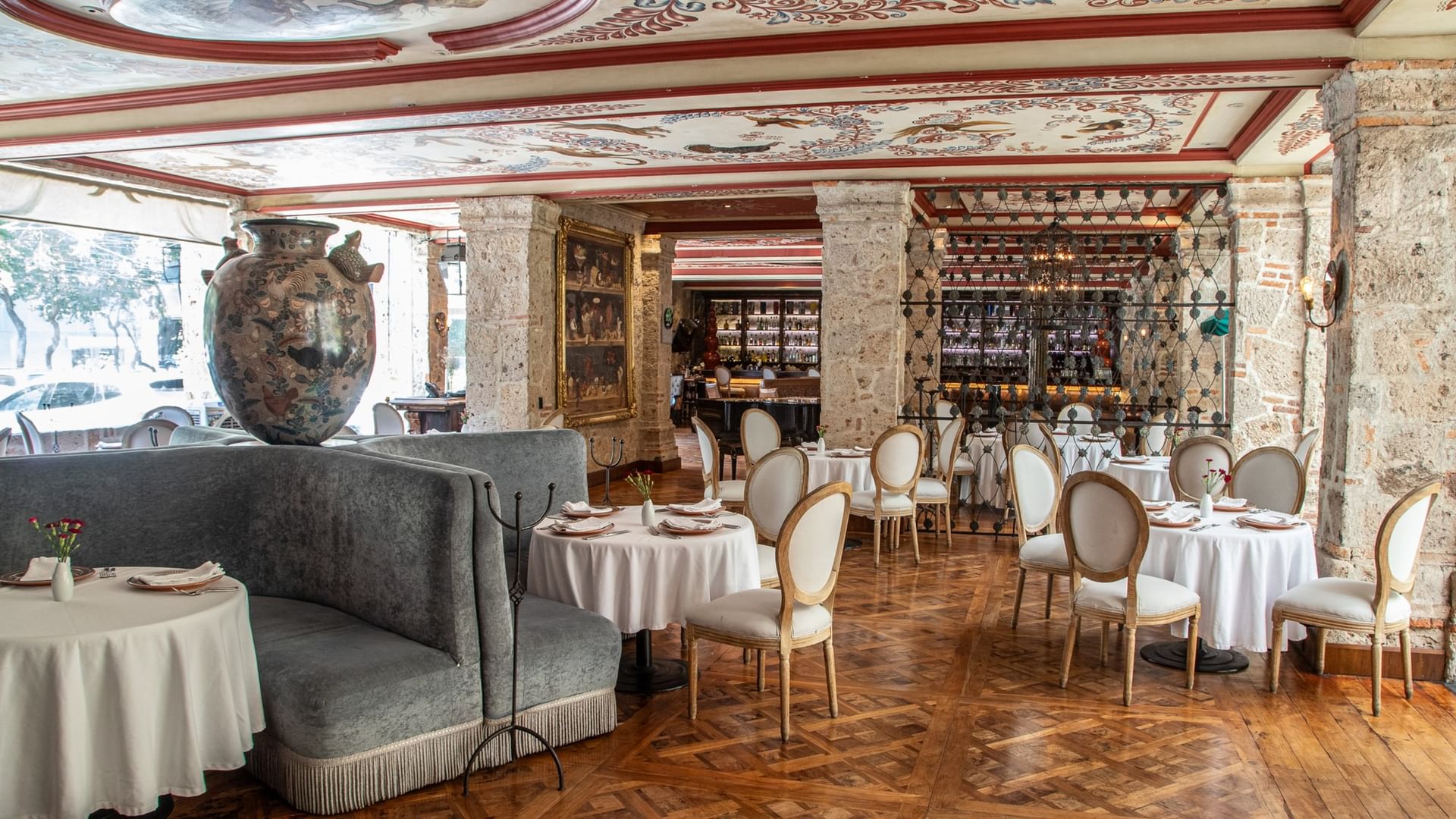 Tierra Mia restaurant with elegant white-clothed tables and ornate ceiling at Quinta Real Guadalajara in Guadalajara