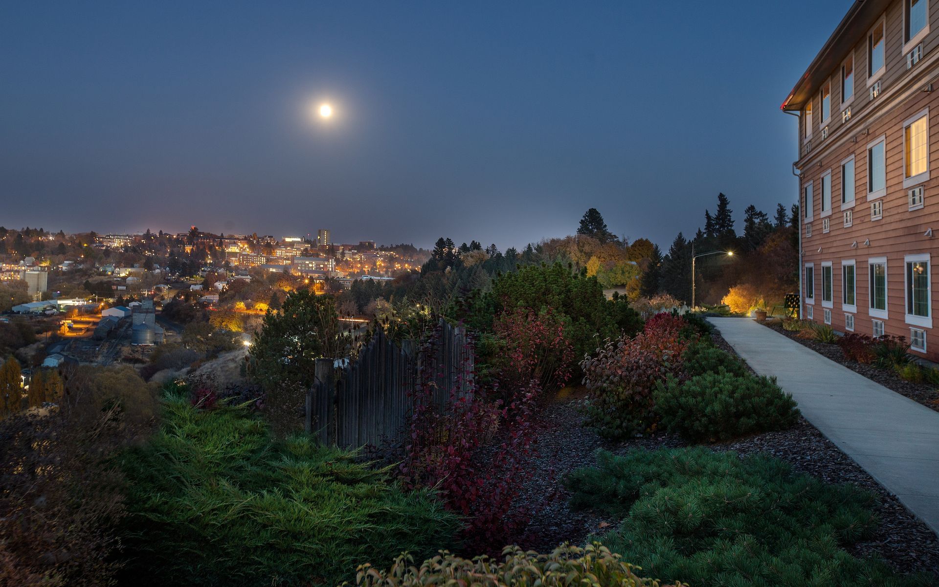 Exterior of Coast Hilltop Inn overlooking valley at night with m