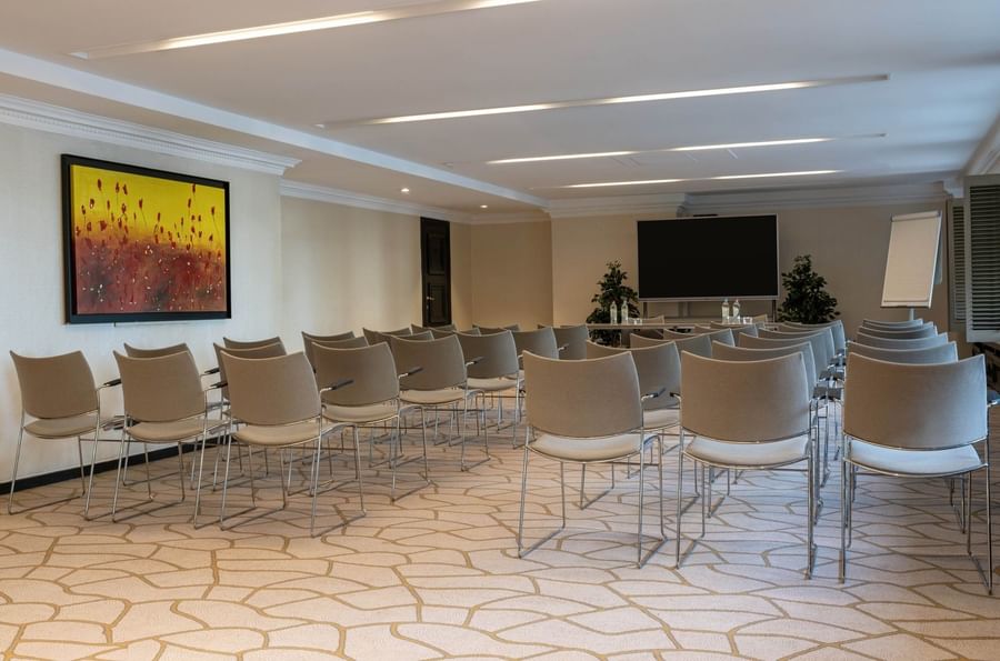 Theater-style Barsey III room with chairs facing a large TV and colorful wall art at Hotel Barsey by Warwick