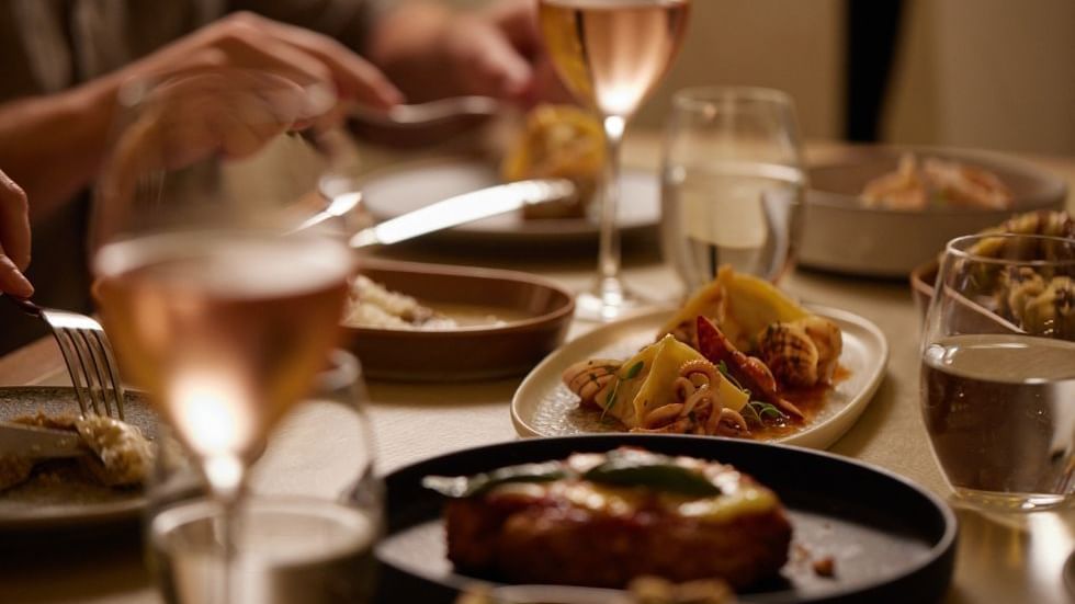 Close-up of dinner setting with wine glasses & dishes in Modo Mio at Crown Promenade Perth