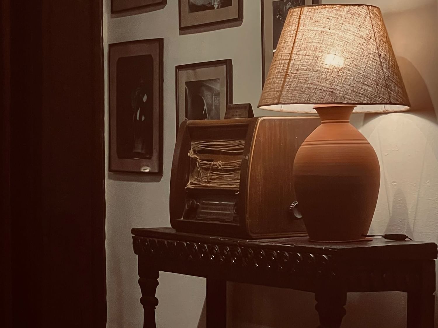 Table lamp on a wooden table by a wall with art in Fusion Bar at Dwarika's Hotel Kathmandu