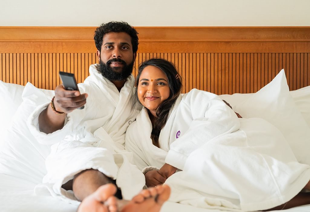 Couple in bed at the Coast Capri Hotel