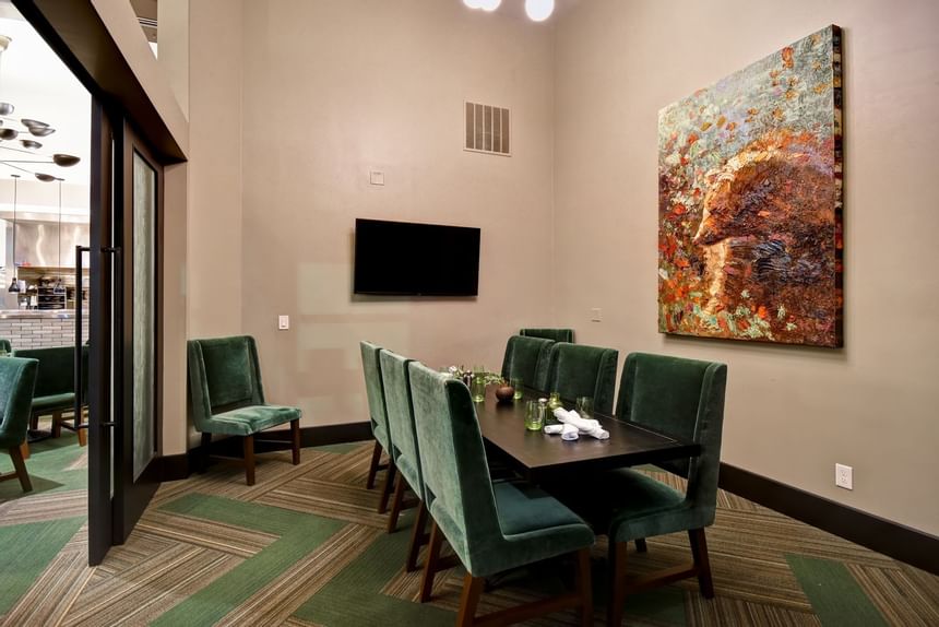 a painting hanging over a public dining table