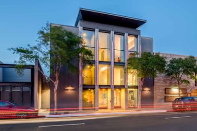 Exterior of Hotel Keen at dusk, with streetlights illuminating the dark facade and glass entrance