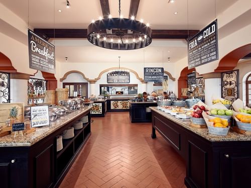 Tomates grand breakfast buffet area with multiple food stations under a large chandelier at Hacienda Del Mar Los Cabos.