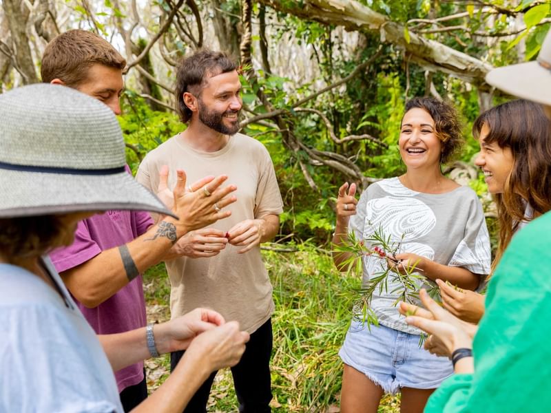 Tour guide with a branch in the hands talking to a group near Sofitel Brisbane Central
