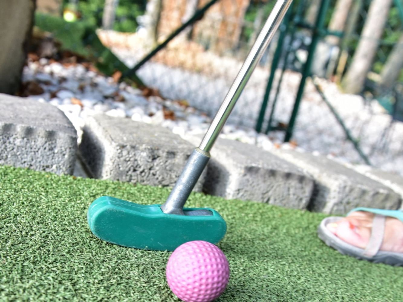 Close-up of a person playing golf with a pink ball in Wonder Mountain Fun Park near Juniper Hill Inn