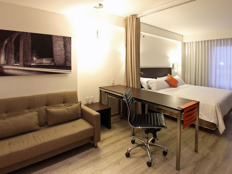 King bed with working desk & sofa in Loft Room at Fiesta Inn