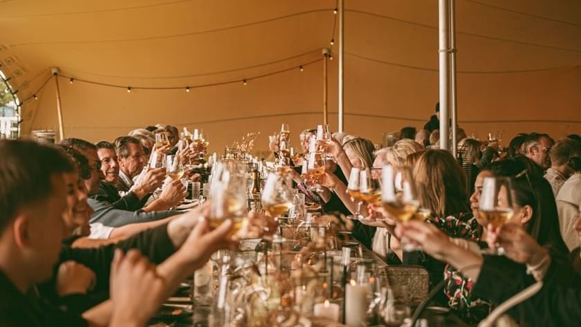 Long lunch at Cabin Fever Fest with guests cheersing with wine glasses