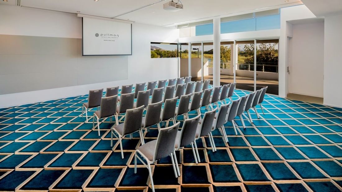 Chairs arranged with screen in meeting room at Pullman Magenta Shores
