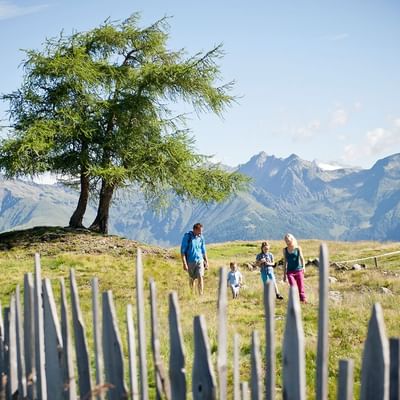 A family on a hike in the fields near Falkensteiner Hotels