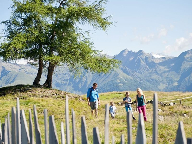 A family on a hike in the fields near Falkensteiner Hotels