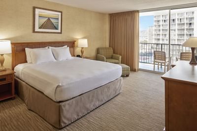 King bed & a single sofa with a private balcony in City View at Waikiki Resort Hotel by Sono