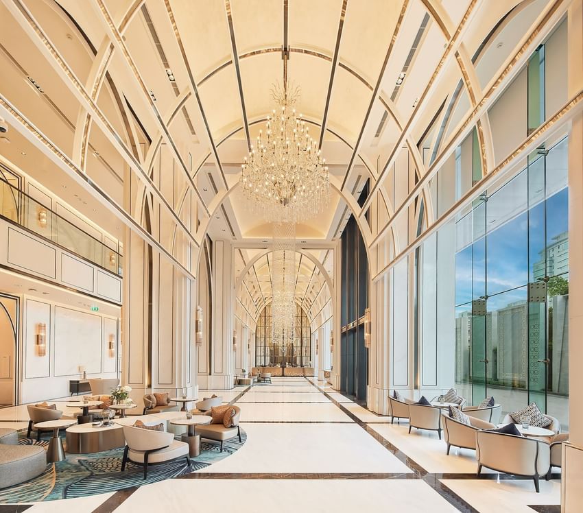 Lobby lounge area with a chandelier and city view at Eastin Hotels