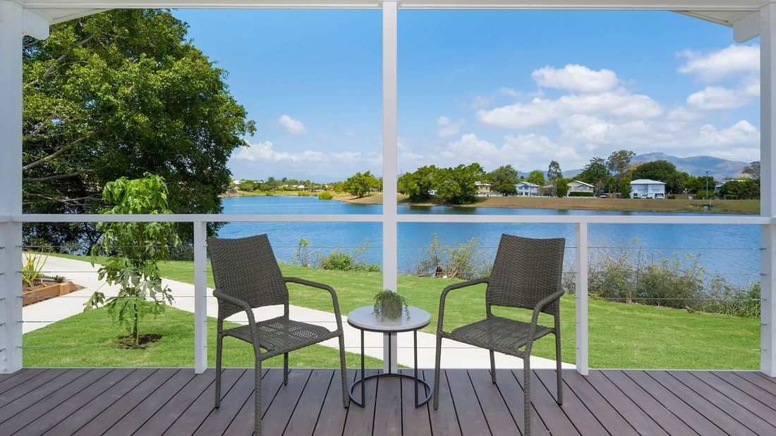 Deluxe Bungalow 2 Bedroom balcony view with two chairs and a table overlooking a serene lake at Mercure Hotel Townsville