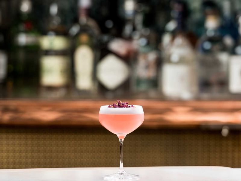 Cocktail with flower garnish on bar counter in TWR at Crown Towers Perth