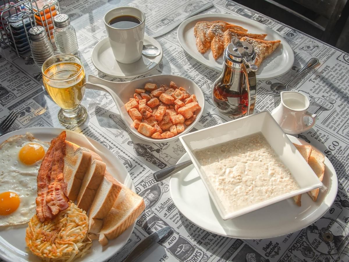 Plates of breakfast food with coffee.