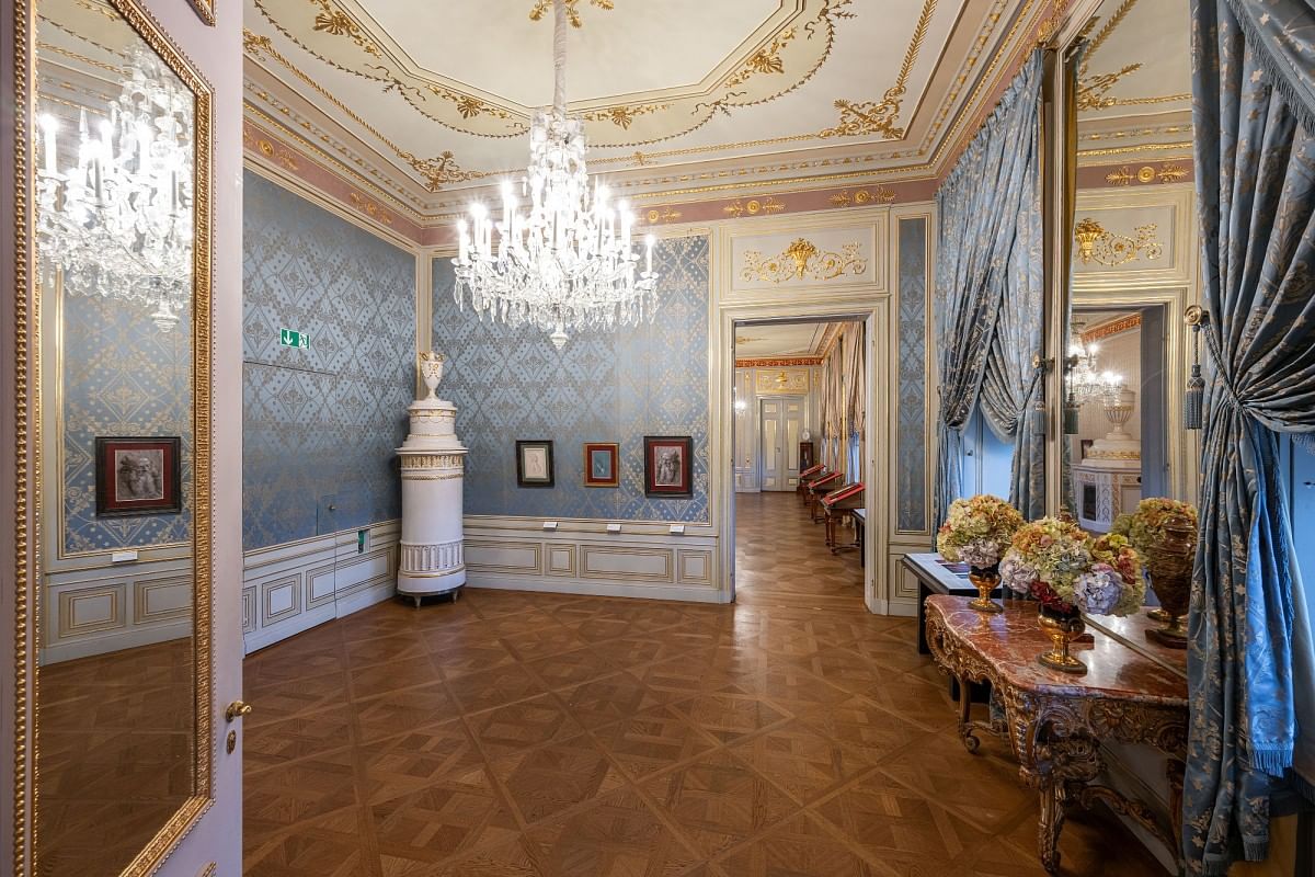 View of the Small Spanish Apartment in the state rooms of the Albertina featuring ornate ceilings, crystal chandeliers, and neoclassical blue and gold wall decor.