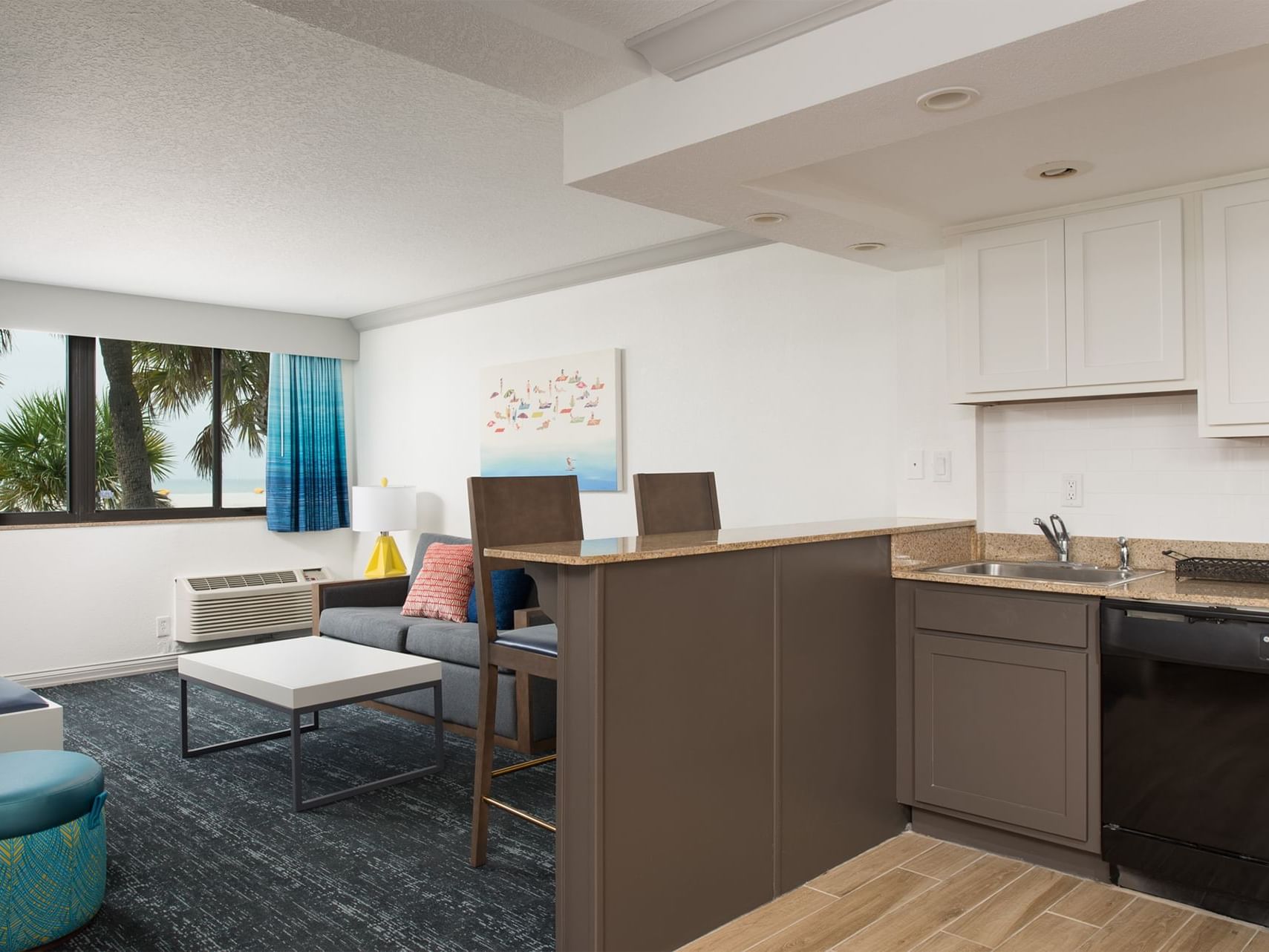 Kitchen & living area with carpeted floors in Scallop Suite at Bilmar Beach Resort