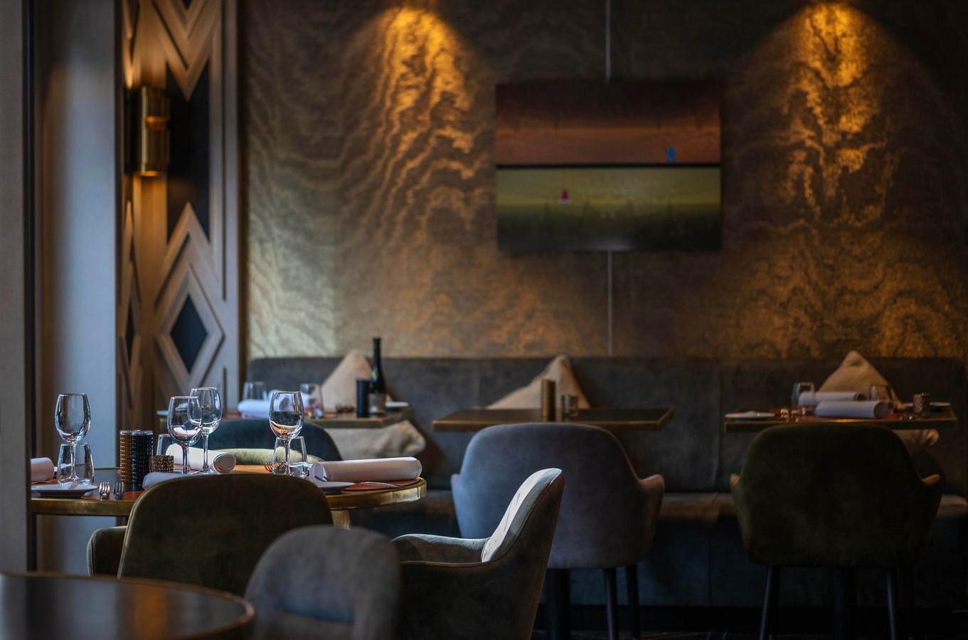 Elegant dining area with cushioned seating, artwork, and wine glasses at Hotel Barsey by Warwick 