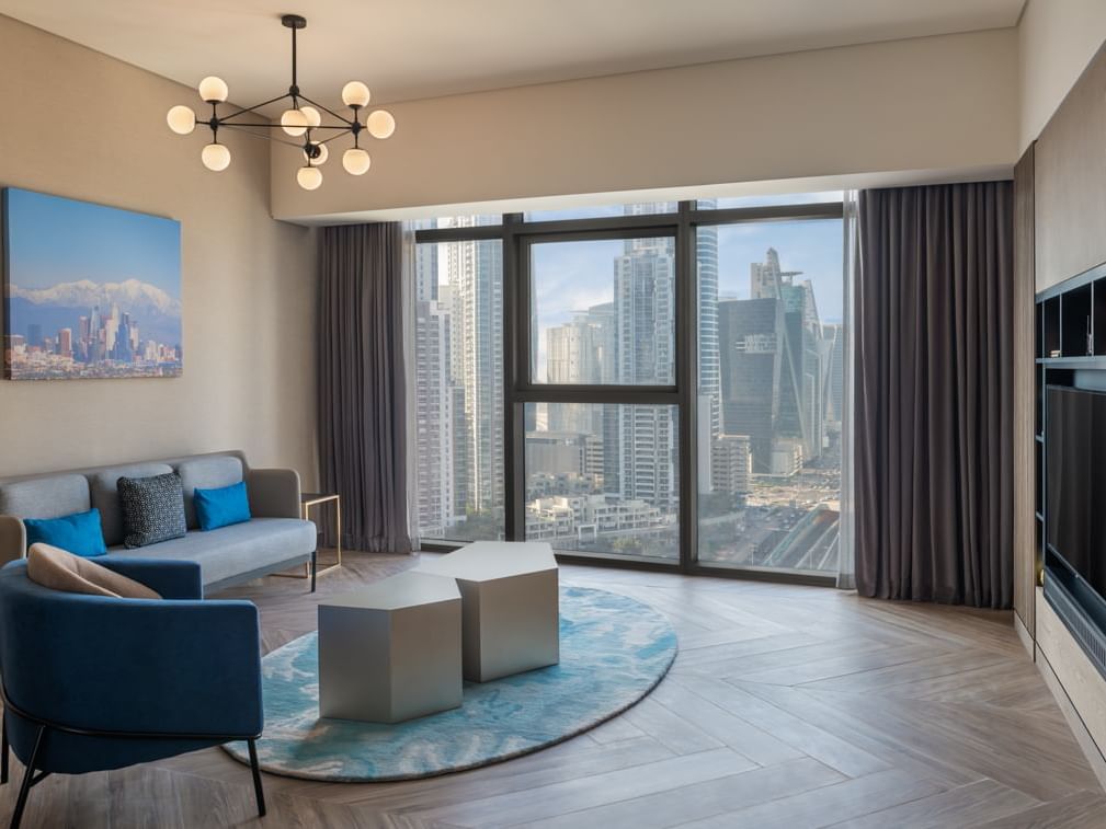 Spacious living area with a TV by the balcony view in Blockbuster Suite at Paramount Hotel Midtown