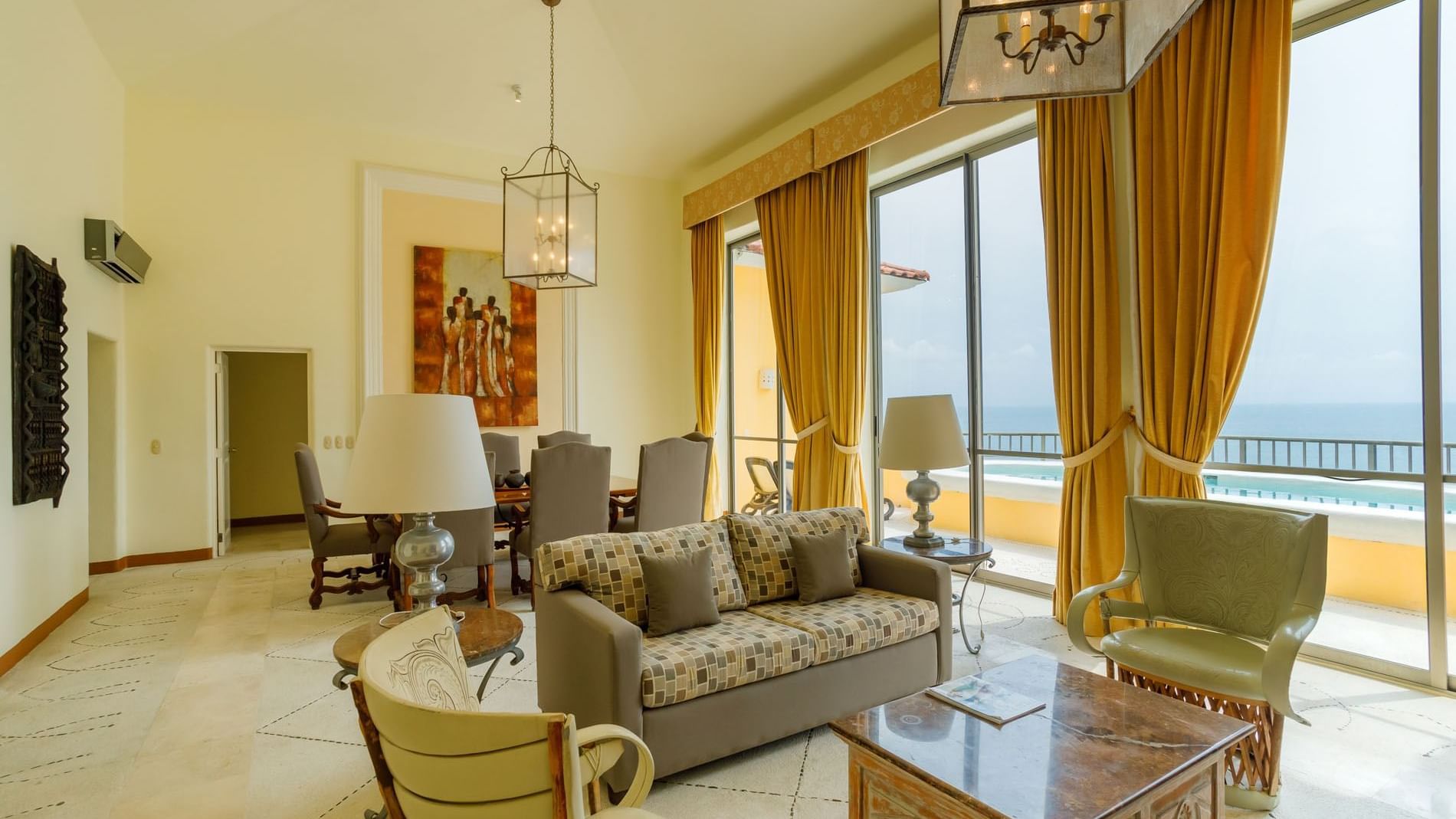 King Presidential Suite with a modern sofa, dining area, and large windows facing the ocean at Quinta Real Acapulco