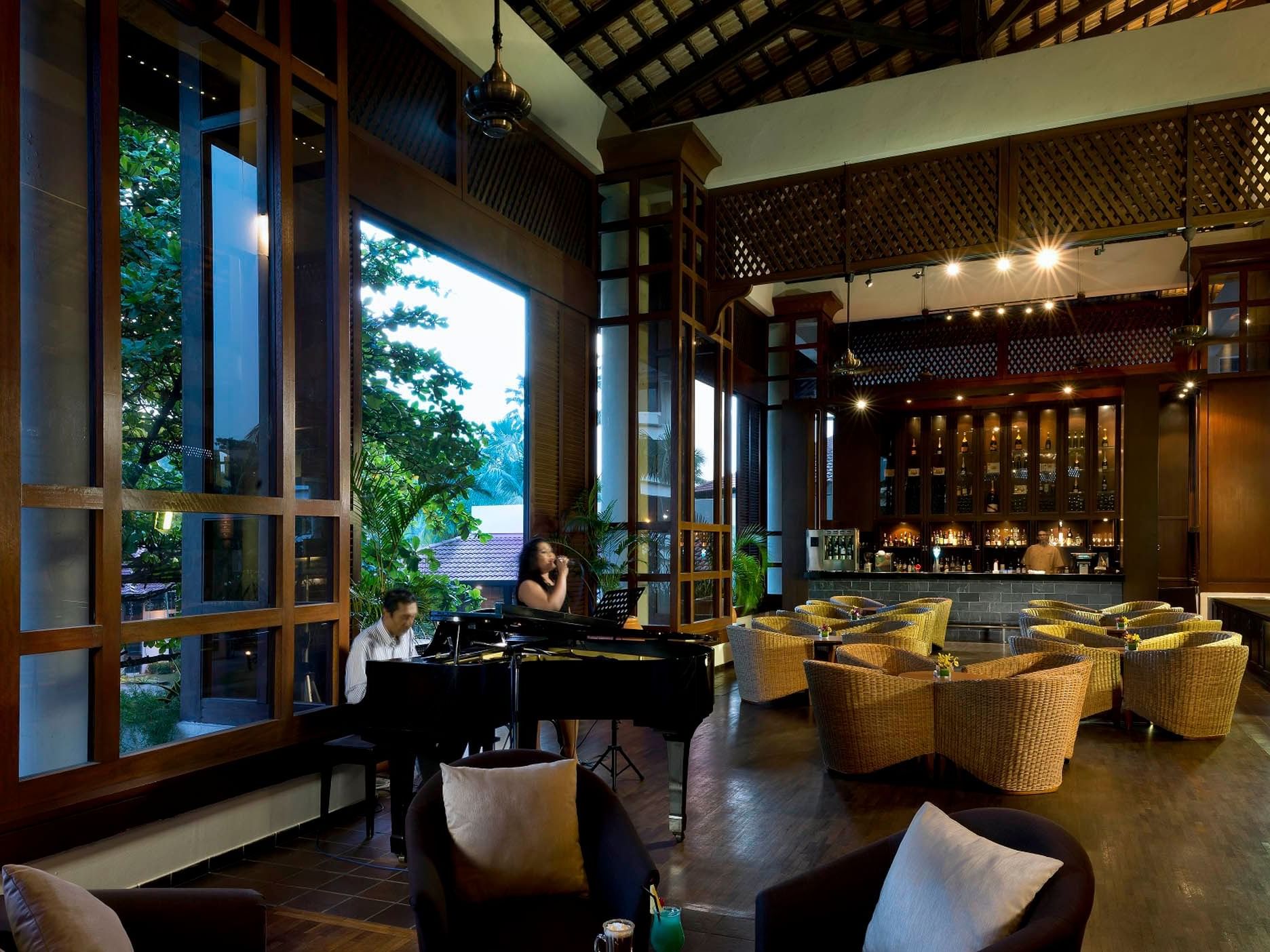 Bayu Lounge with a grand piano, surrounded by cozy seating and a well-stocked bar at Saujana Hotel Kuala Lumpur